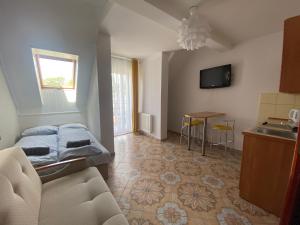 a living room with a bed and a kitchen at Twój Port in Krynica Morska