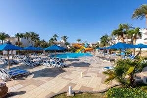 einen Pool mit Stühlen, Sonnenschirmen und einer Rutsche in der Unterkunft Naama Bay Hotel & Resort in Sharm El Sheikh