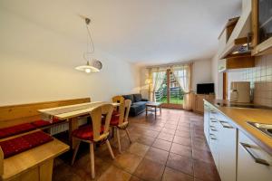 een keuken en een woonkamer met een tafel en stoelen bij Naturresidenz Theistadl Apt 101 in Pracupola