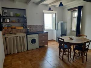 a kitchen with a table and a washing machine at Vacances près de Saint Florent in Olmeta-di-Tuda