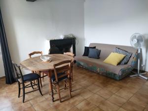 a living room with a table and a couch at Vacances près de Saint Florent in Olmeta-di-Tuda