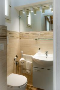 W łazience znajduje się toaleta, umywalka i lustro. w obiekcie La Loggia del Buon Tempo w mieście Polignano a Mare