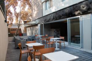 a restaurant with tables and chairs on a deck at Gran Hotel Dakar in Mendoza