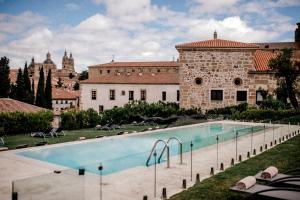 a large swimming pool in front of a building at Hospes Palacio de San Esteban in Salamanca
