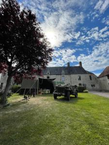 un camión estacionado en un patio frente a un edificio en La Ferme Delaunay en Saint-Côme-du-Mont