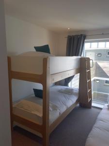 Ce dortoir comprend 2 lits superposés et une fenêtre. dans l'établissement The Towan Lookout, à Newquay