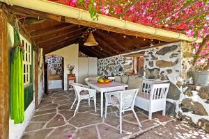 a patio with a table and chairs and flowers at Casa Nonito in Tijarafe
