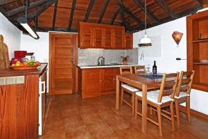 a kitchen with wooden cabinets and a wooden table at Casa Nonito in Tijarafe +10 photos