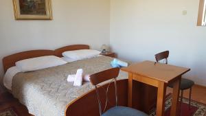 1 dormitorio con 1 cama con mesa y sillas en Room Marin, en Jelsa