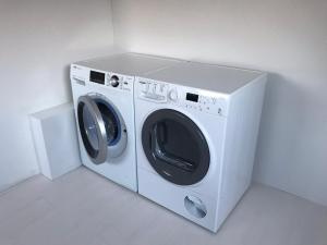 een witte wasmachine in een witte kamer bij Dorpsweg 18 nummer 7 in Callantsoog