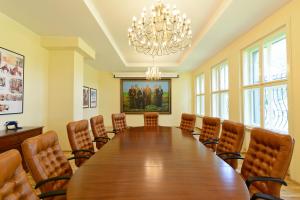 特爾古穆列什的住宿－Pensiunea Elphin，一间会议室,配有一张大木桌子和椅子