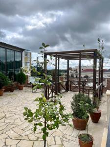 a patio with potted plants and a gazebo at Hotel Verdzi in Kutaisi
