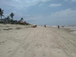 a group of people walking on a beach at Apartamento à 50 metros da praia - Itanhaém in Itanhaém