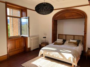 una camera da letto con un letto grande e una grande finestra di O'Cottage jardin ad Annonay