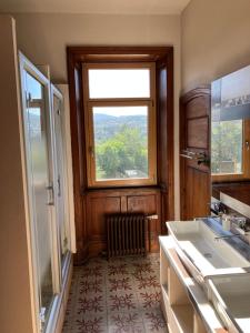 a bathroom with two sinks and a window in it at O'Cottage double jardin in Annonay