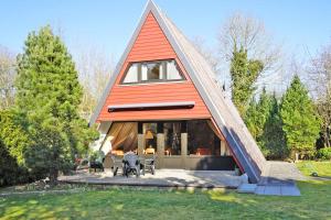 una casa con techo triangular con mesas y sillas en Zeltdachhaus mit W LAN sehr strand, en Damp