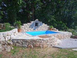 a swimming pool in a stone wall with a stone oven at House Mali dvori in Krivodol