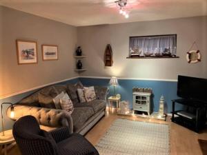 a living room with a couch and a television at Coastal Chalet Retreat in St Margaret's Bay in St Margarets at Cliff