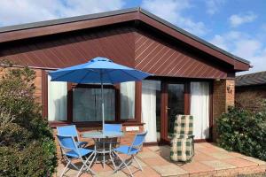 a table and chairs with an umbrella on a patio at Coastal Chalet Retreat in St Margaret's Bay in St Margarets at Cliff
