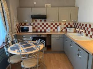 a kitchen with a table with chairs and a counter top at Lovely 5 Person Chalet in St Margaret's at Cliffe in St Margarets at Cliff