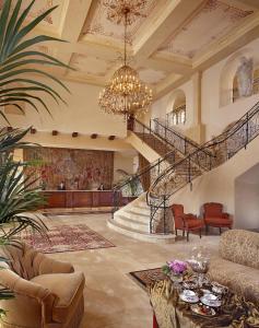 a living room with a staircase and a chandelier at Ayres Hotel Manhattan Beach in Hawthorne