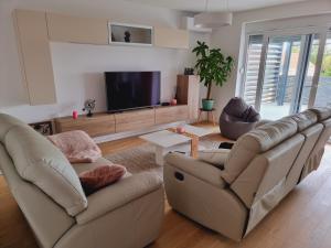 een woonkamer met 2 banken en een flatscreen-tv bij Skitnica Prestige in Koprivnica