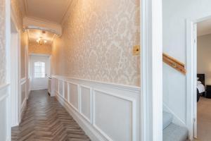 un corridoio di una casa con pareti bianche e una scala di Scotston Villa - 5 bedroom house with hot tub a Forfar