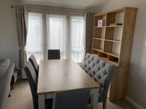 a dining room with a wooden table and chairs at 8 BIRTH LODGE ON CAYTON BAY HOLIDAY PARK in Scarborough