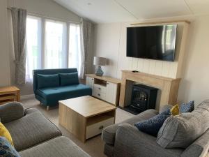 a living room with a couch and a fire place at 8 BIRTH LODGE ON CAYTON BAY HOLIDAY PARK in Scarborough