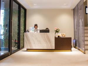 a woman sitting at a reception desk in an office at PING DIAMOND HOTEL in Hanoi