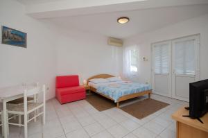 Apartments Branimir في نوفي فينودولسكي: غرفة نوم بسرير وكرسي احمر