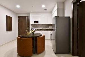 a kitchen with a small table and a refrigerator at JUFFAIR BOULEVARD HOTEL & SUITES in Juffair