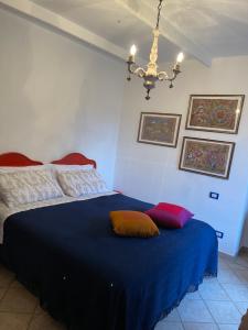 a bedroom with a blue bed with two pillows on it at La casa tra i vigneti in Montecalvo Versiggia