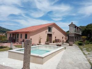 una casa con piscina frente a una casa en Galicia en Forcarei