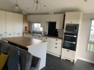 a kitchen with white cabinets and a counter top at 8 BIRTH LODGE ON CAYTON BAY HOLIDAY PARK in Scarborough