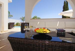 een tafel met een fruitschaal en een glas wijn bij Villa Greko in Protaras
