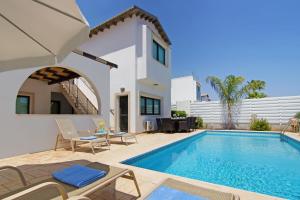 een villa met een zwembad en een huis bij Villa Greko in Protaras