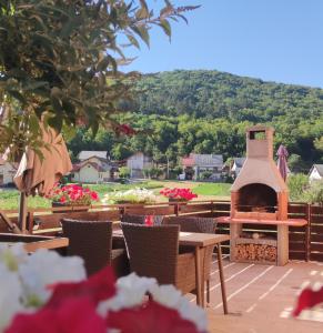 a outdoor patio with a fireplace and tables and chairs at Apartman Urban Nature in Otočac