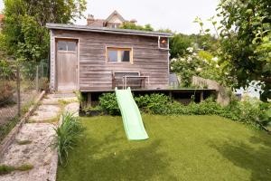 een klein huis met een groene glijbaan in een tuin bij L'Atelier du Pêcheur in Fécamp