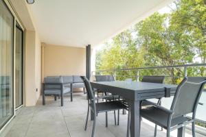een patio met een tafel en stoelen op een balkon bij Les Merisiers in Lorgues