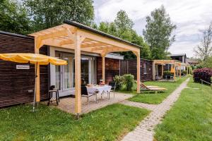 eine Terrasse mit einem Tisch und einem Sonnenschirm in der Unterkunft Relax Camping Seewirt in Feldkirchen in Kärnten