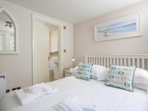 1 dormitorio con cama blanca y almohadas azules en Keepers Lodge, Hillfield Village, en Dartmouth