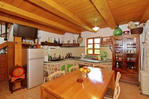 a kitchen with a wooden table and a refrigerator at House Flamingo in Pašman