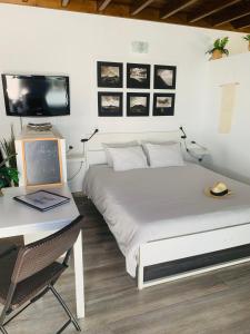 a bedroom with a bed and a desk with a computer at Loft La ISLA in Playa Blanca