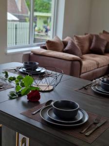 a table with plates and utensils on it in a living room at Tomo Namas 