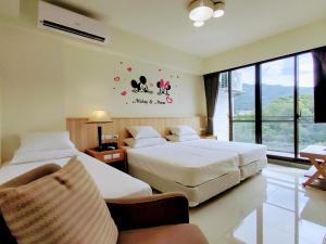 a hotel room with two beds and a window at 礁溪幸福民宿Jiaoxi Happy Homestay in Jiaoxi