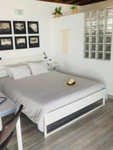 a white bedroom with a bed with a hat on it at Loft La ISLA in Playa Blanca