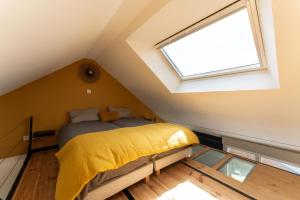 um quarto com uma cama com um cobertor amarelo e uma janela em Josianne em Mers-les-Bains