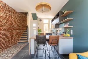 a kitchen with a brick wall and a bar with stools at Josianne in Mers-les-Bains