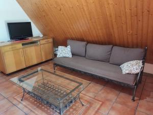 a living room with a couch and a tv at Cabaña con piscina in Baiona
